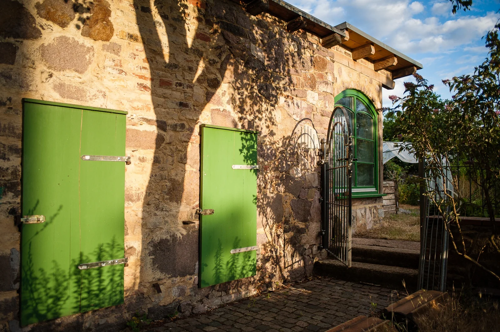 Grüne Türen und ein offenes Tor am Pfarrhof