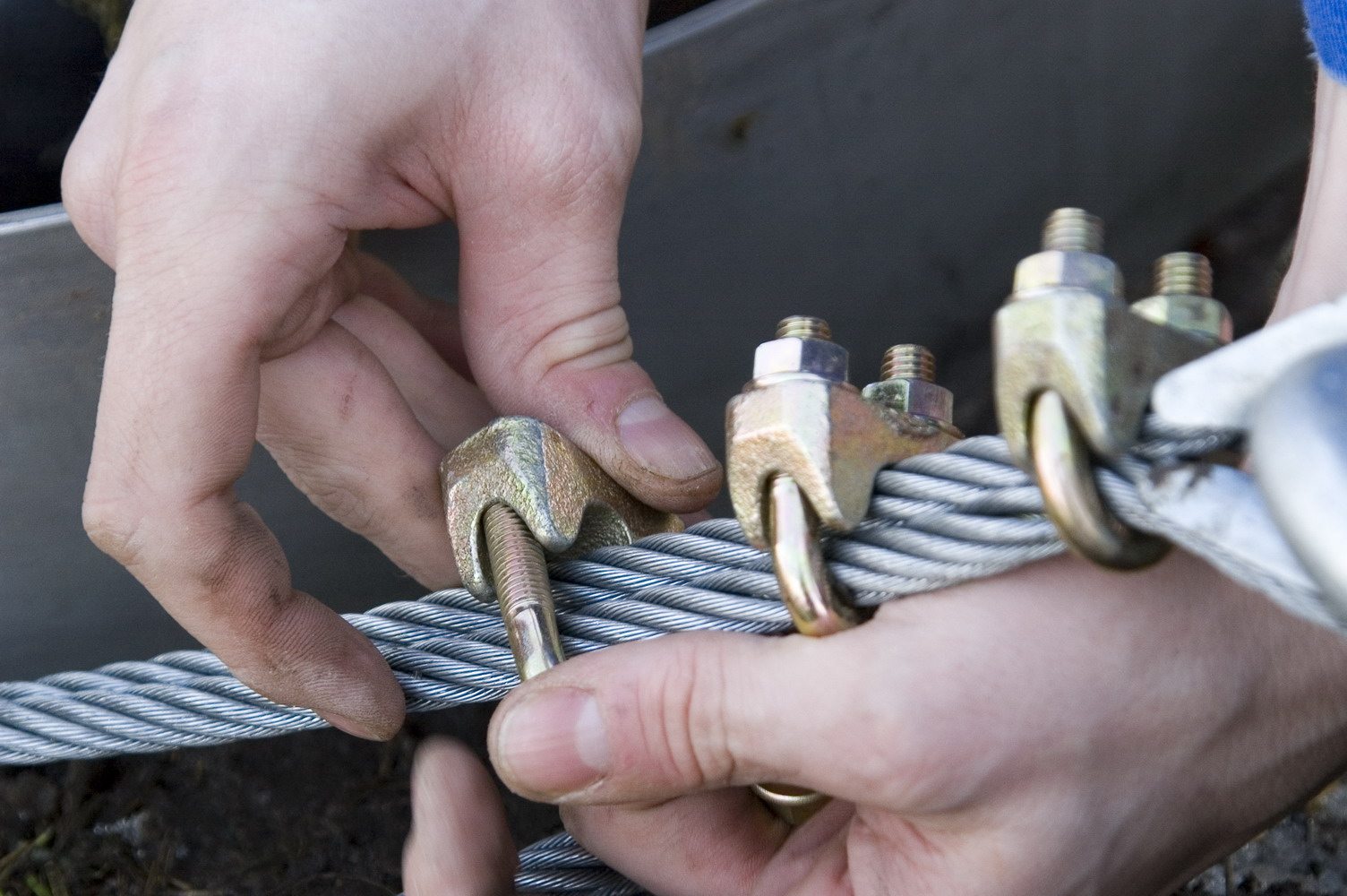 Hände verbinden Seil und Metallbeschläge
